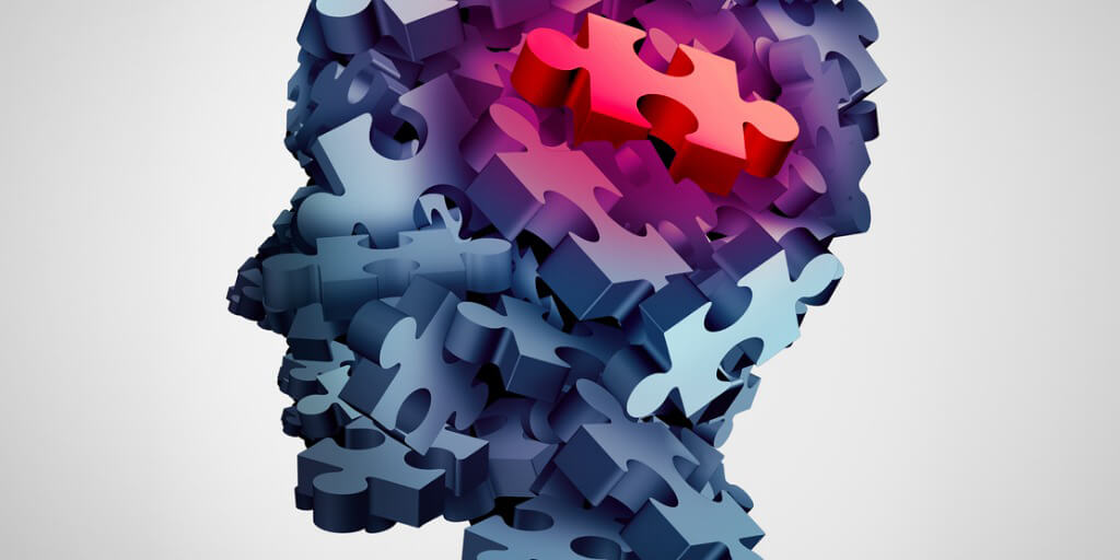 Illustrated figure head made up of 3-D puzzle pieces with one red piece in part of the brain