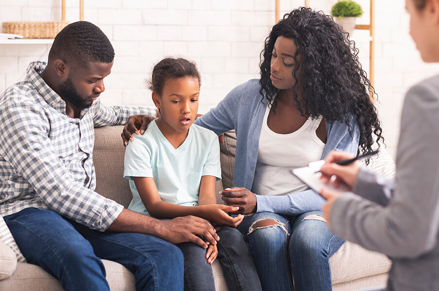 A black family sitting with a family therapist
