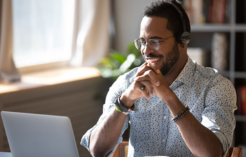 Black male at his laptop participating virtually in a Customized training session