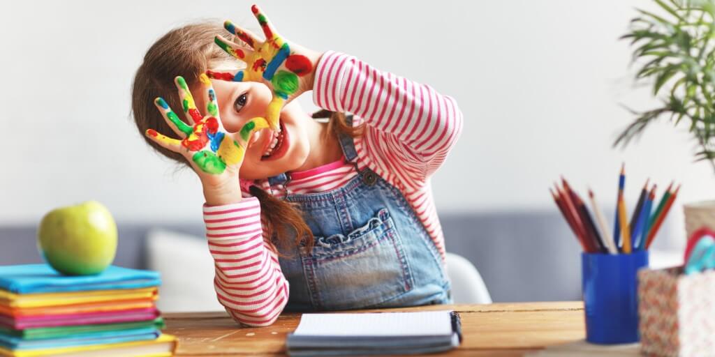 Creative approaches to support grief image with child's hands covered in paint