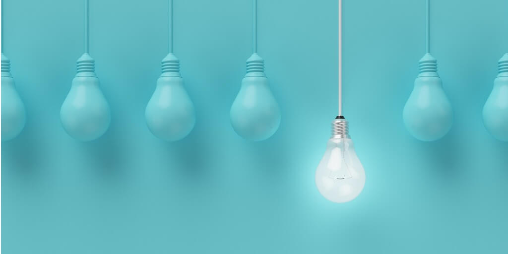 Leadership and motivation image of a row of lightbulbs with one shinning