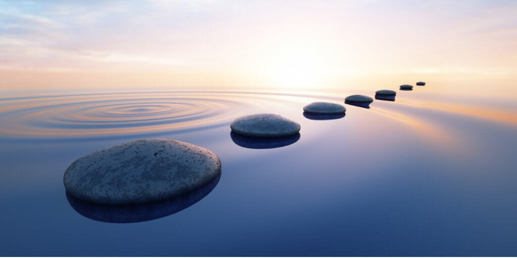 stepping stones across water with sunrise in background