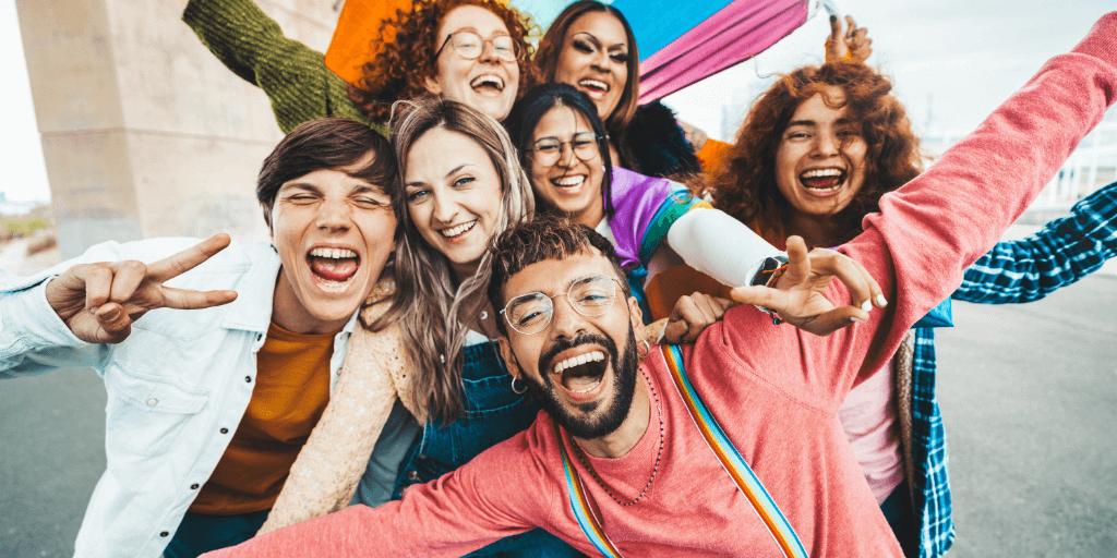 Happy group of adolescents with 2SLGBTQ+ flag