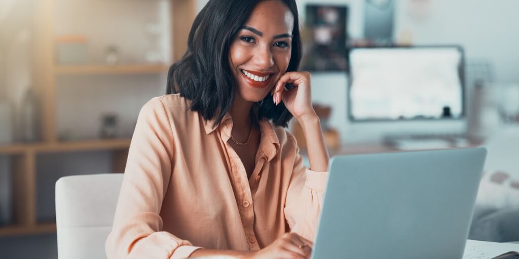 Professional person sitting in front of computer smiling at camera