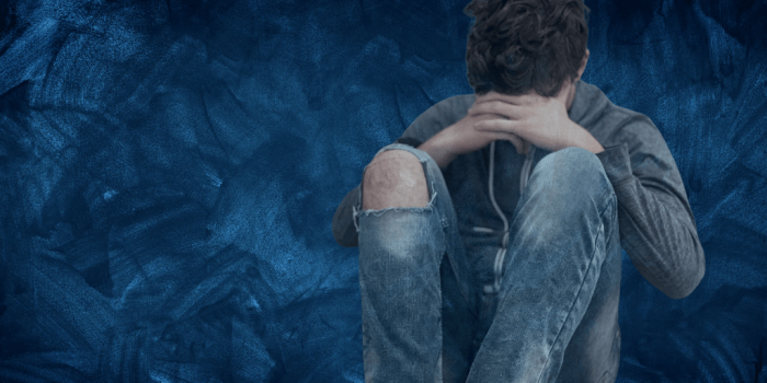 image of teen sitting alone with head/face lowered self-harm and suicide in teens