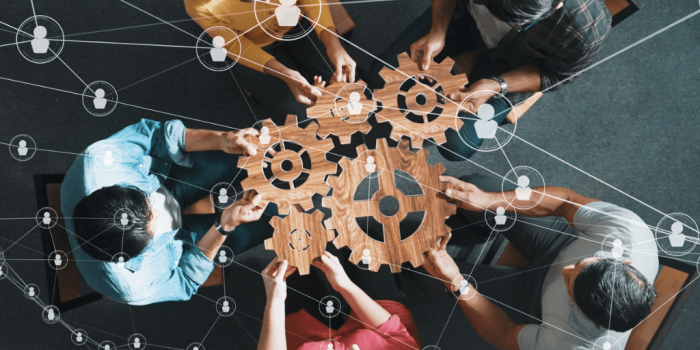 group of professionals holding gears working together for workplace wellness