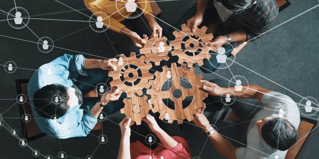 group of professionals holding gears working together for workplace wellness