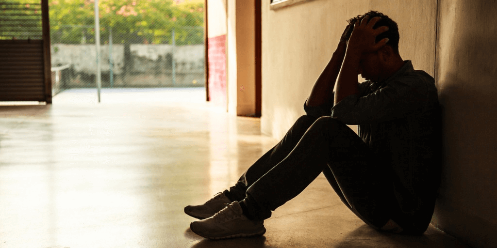 Image of a teenager sitting alone looking angry or upset for adolescent violence and mental health