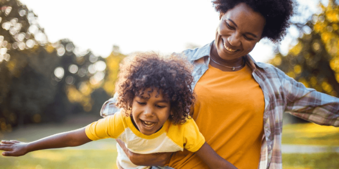 smiling mother outside carrying happy child for ADHD in motherhood: Identification and treatment