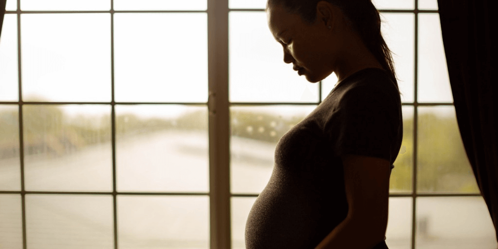 pregnant woman standing in front of window for Perinatal Obsessive Compulsive Disorder (pOCD)
