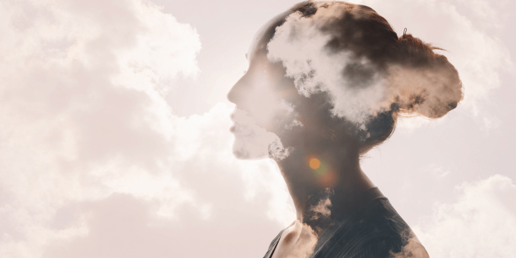 profile of person with clouds and faded images representing schema therapy for trauma